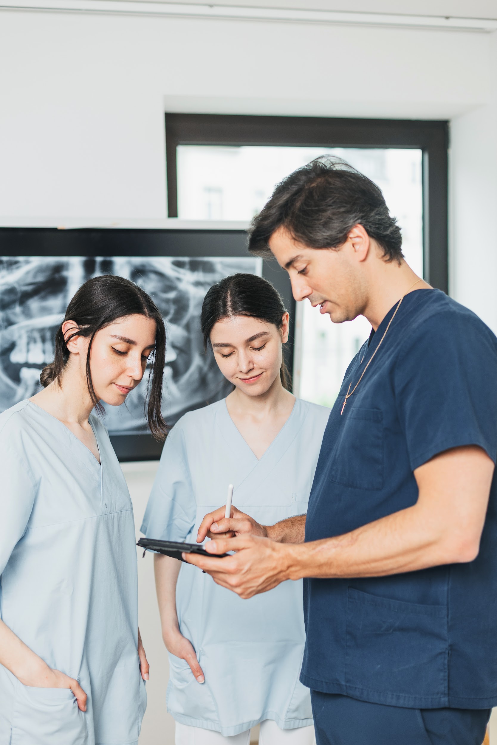 Dr. Rodríguez Ruíz erklärt zwei Patientinnen die Planung am Tablet